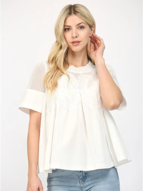 Woman wearing a white blouse with sheer sleeves on a white background