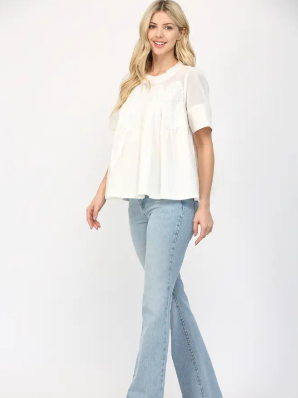 Woman wearing a white blouse and light blue jeans on a white background