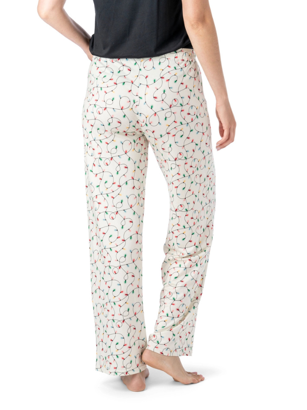 Person wearing white pajama pants with a colorful christmas lights pattern on a white background