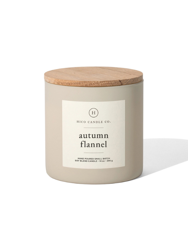 Candle with wooden lid labeled 'autumn flannel' on a white background