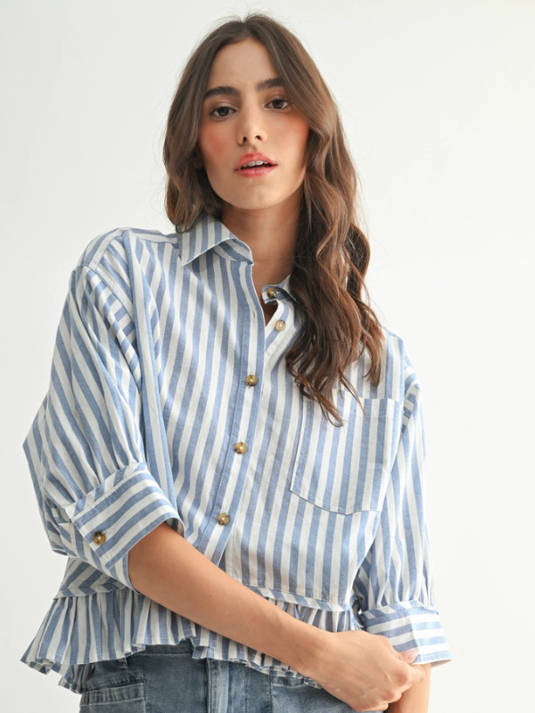 Woman wearing a blue and white striped shirt against a plain background