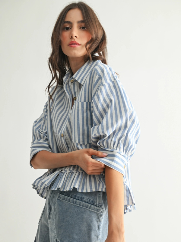 Woman wearing a blue and white striped shirt with a plain background
