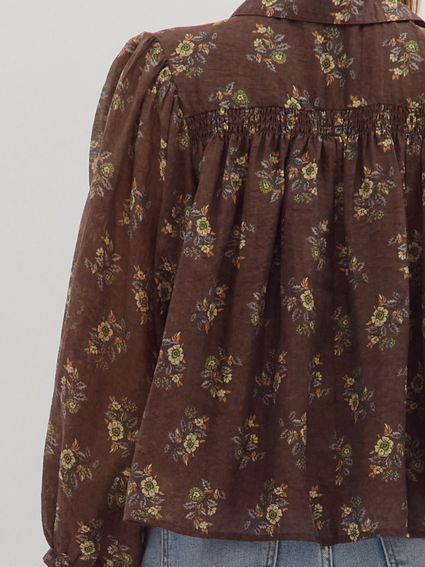 Brown floral patterned blouse on a plain background