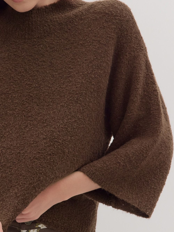 Brown sweater worn by a person on a light gray background