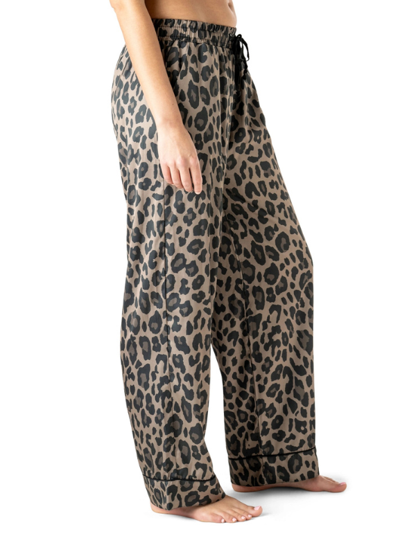 Leopard print pants worn by a person on a white background