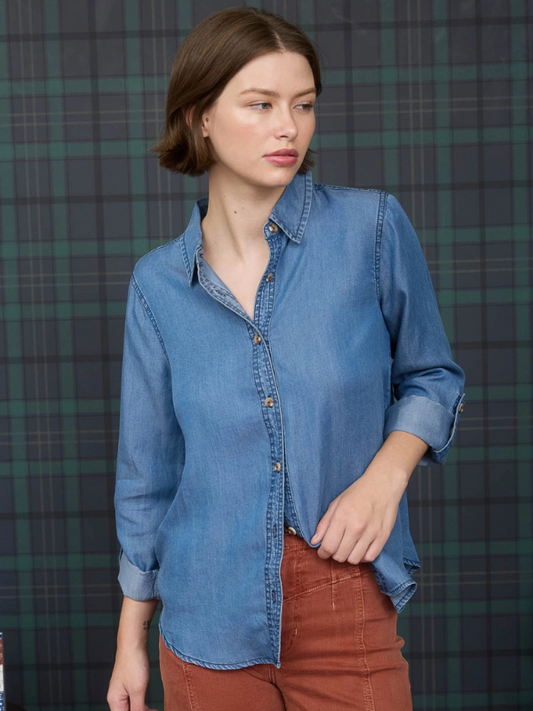Woman wearing a blue denim shirt against a plaid background