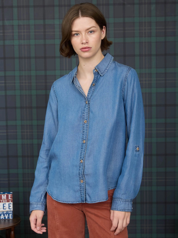 Woman wearing a blue denim shirt against a plaid background