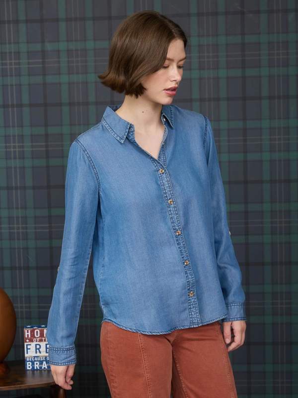 Woman wearing a blue denim shirt against a plaid background