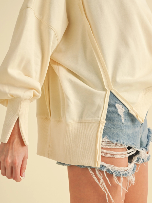 Light-colored jacket worn over a denim skirt on a neutral background