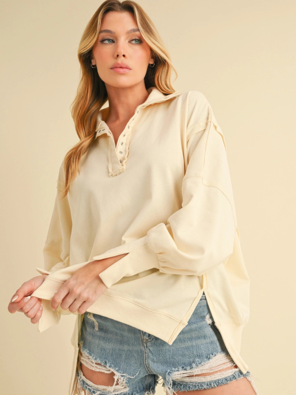 Woman wearing a light yellow blouse and denim shorts on a beige background