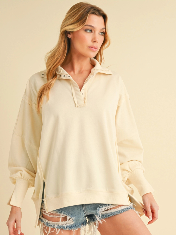 Woman wearing a light-colored blouse with a plain background