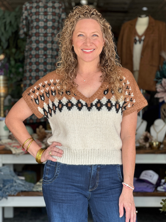 Woman wearing a patterned sweater in a clothing store setting