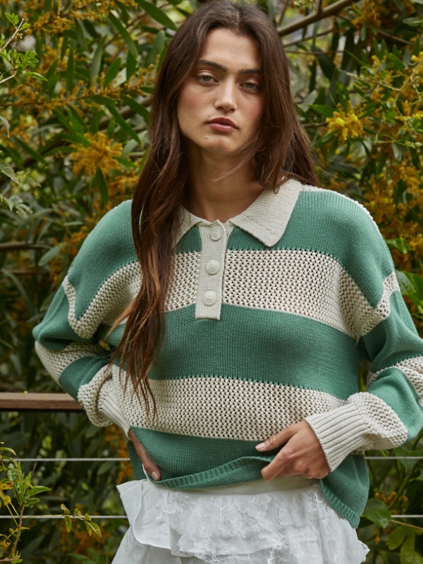 Woman wearing a green and white striped sweater with a blurred natural background