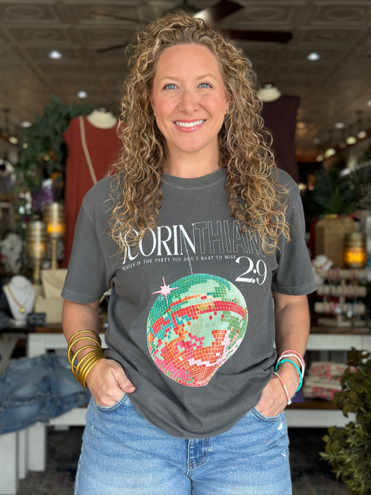 Woman wearing a gray t-shirt with a colorful graphic design in a store setting