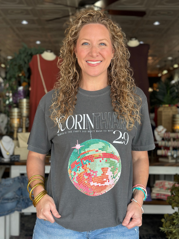 Woman wearing a gray t-shirt with a colorful graphic design in a store setting