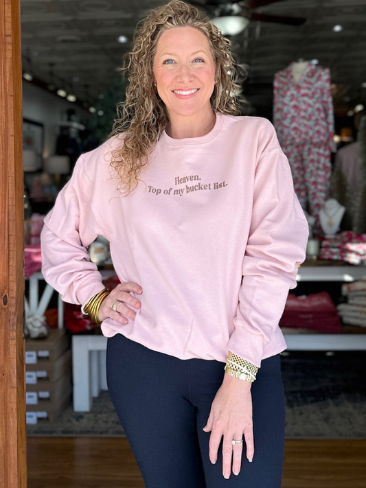 Woman wearing a pink sweatshirt with text in a store setting