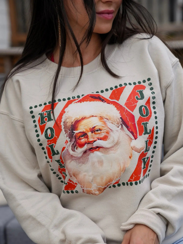 Person wearing a beige sweatshirt with a Santa Claus graphic and 'HOLY JOLLY' text.