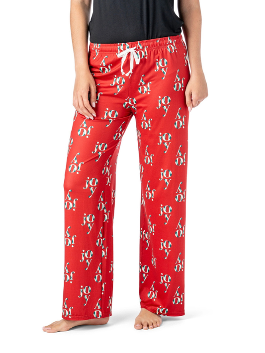 Red pajama pants with 'joy'  print worn by a person on a white background