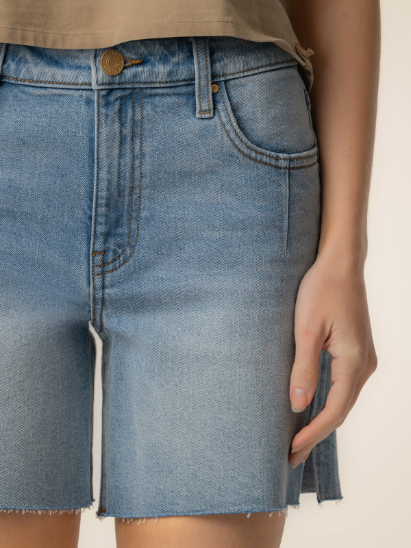 Close-up of a blue denim skirt with a beige background