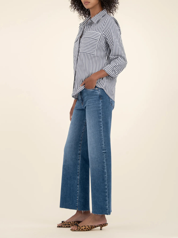 Person wearing a striped shirt and blue jeans on a beige background