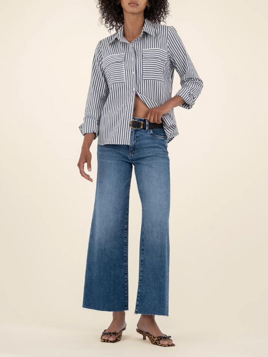 Person wearing a striped shirt and blue jeans on a beige background