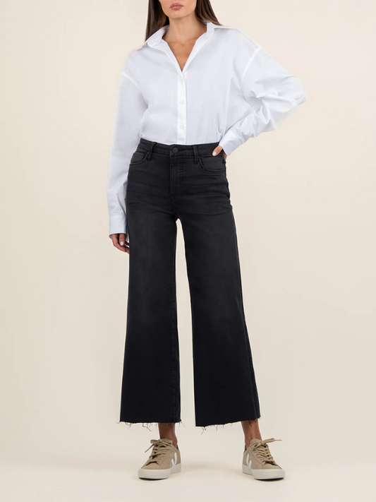 Person wearing a white shirt and black pants on a beige background