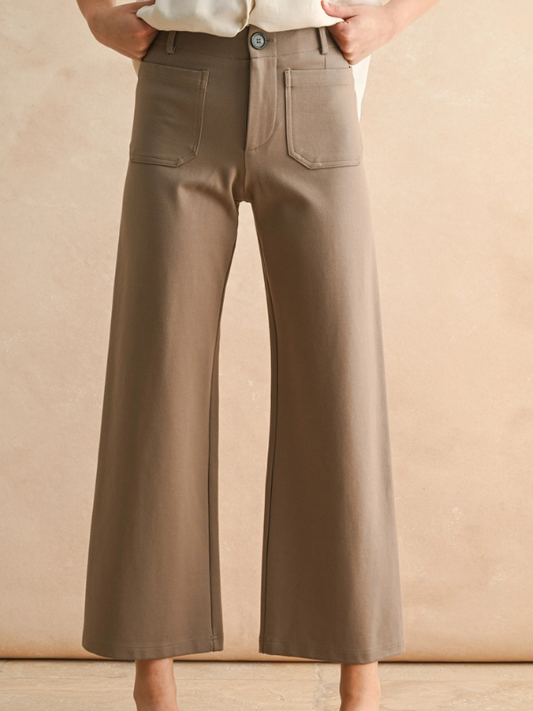 Brown wide-leg pants worn by a person on a beige background