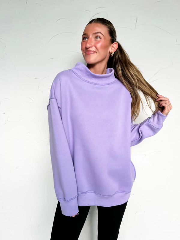 Woman wearing a light purple sweatshirt against a white background