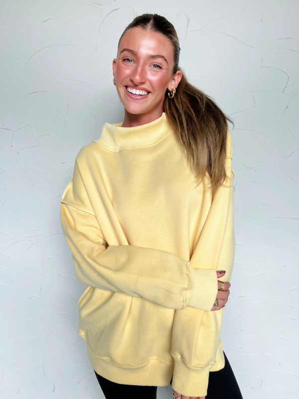Woman wearing a yellow sweater against a white background