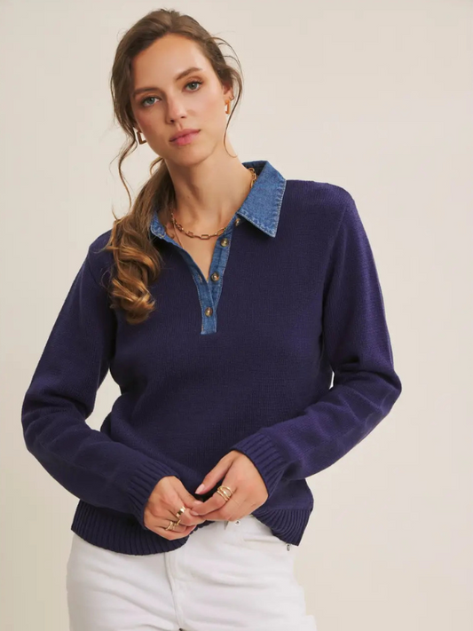 Woman wearing a navy sweater with a denim collar against a beige background