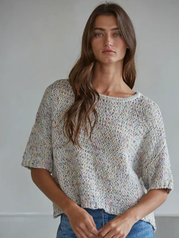Woman wearing a patterned top against a plain background