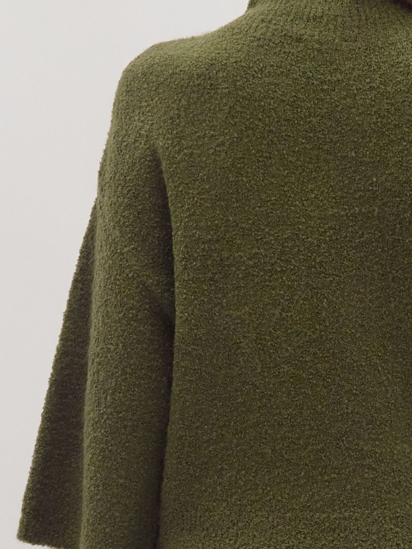 Close-up of a green textured sweater on a light gray background