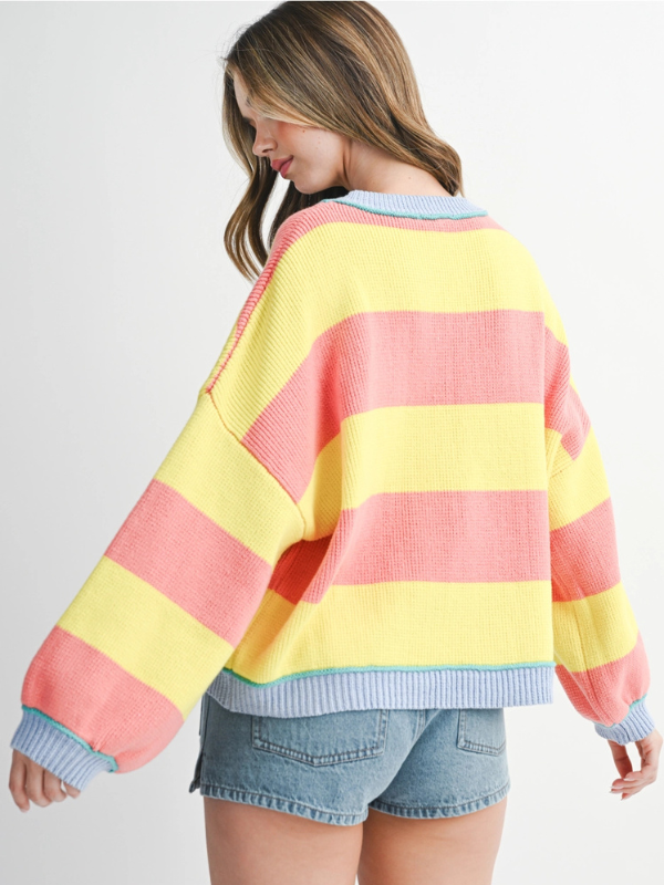 Woman wearing a colorful striped sweater on a white background