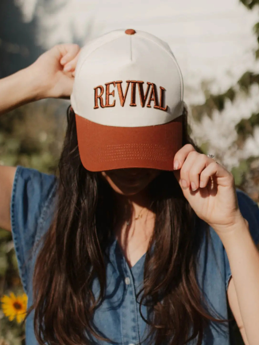 Person wearing a cap with 'REVIVAL' text outdoors
