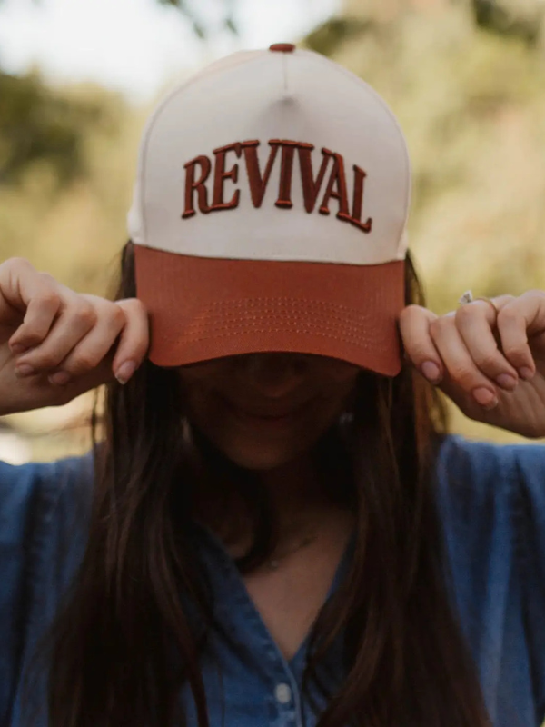 Person wearing a cap with 'REVIVAL' text in an outdoor setting