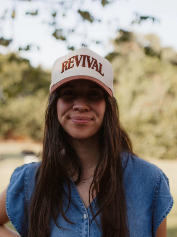 Person wearing a cap with 'REVIVAL' text outdoors