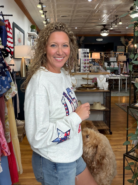 Woman wearing a sweatshirt with star designs in a store setting