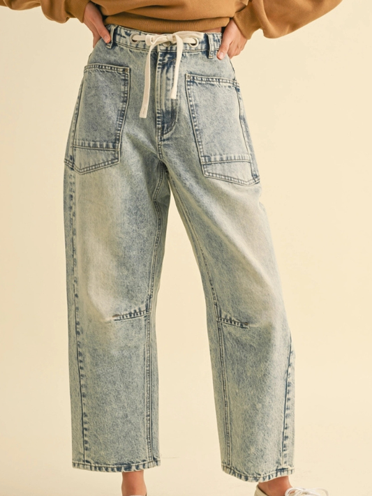 Light blue jeans worn by a person on a beige background