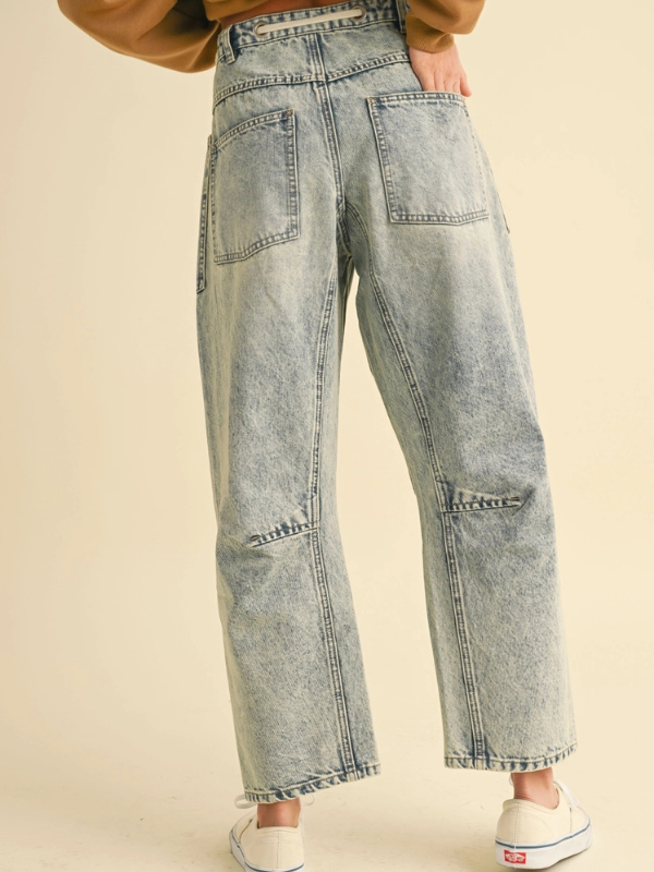 Light blue jeans worn by a person on a beige background