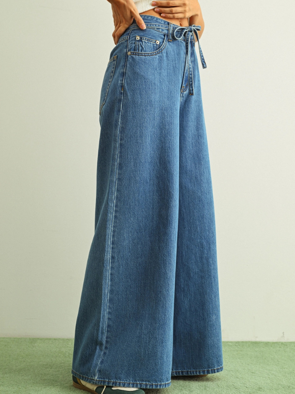 Long blue denim pants on a plain background