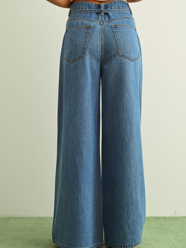 Blue wide-leg jeans on a neutral background