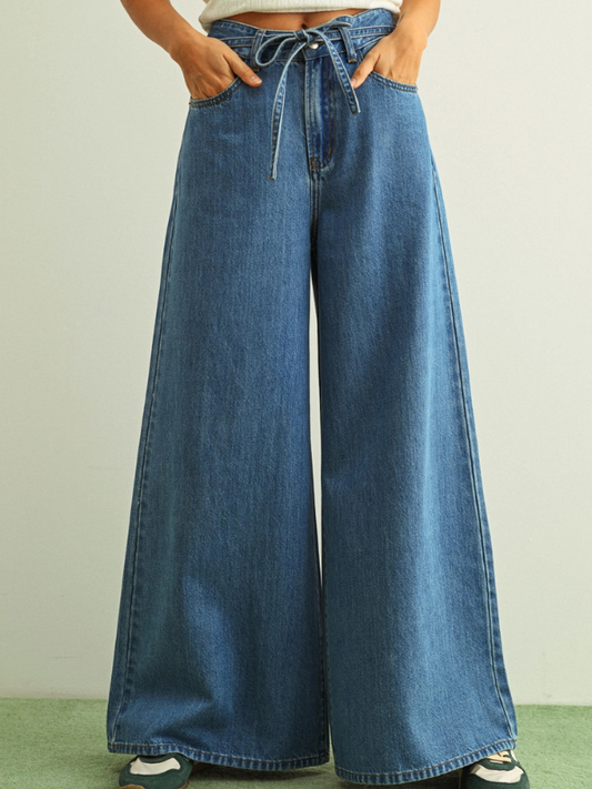 Wide-leg jeans worn by a person on a plain background