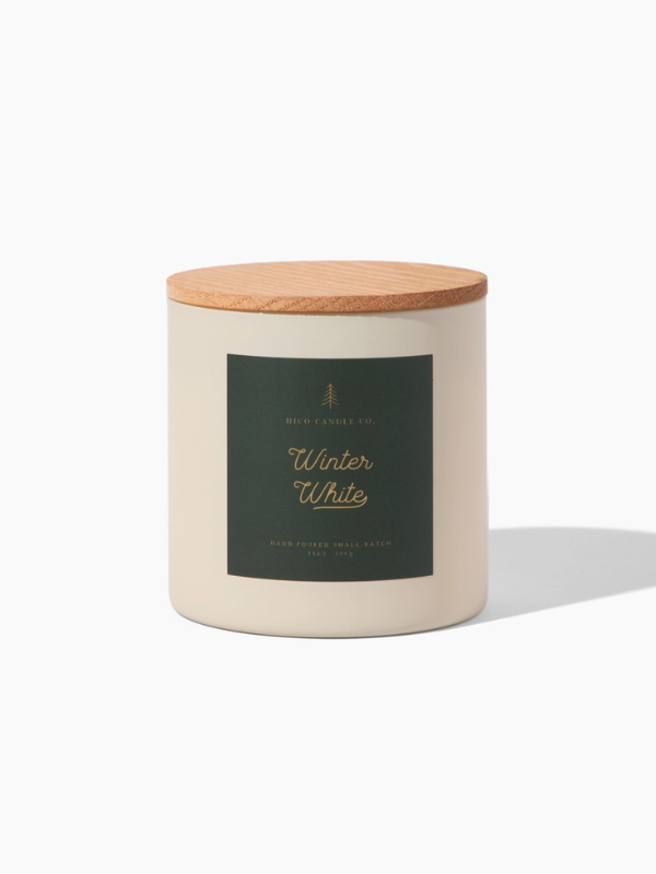 Candle with wooden lid labeled 'Winter White' on a white background