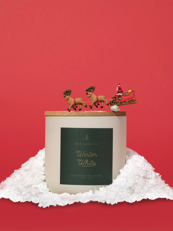 Candle with Santa and reindeer decoration on a red background