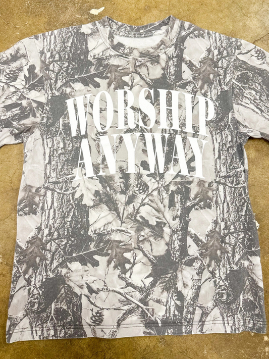 T-shirt with floral pattern and 'Worship Anyway' text on a brown surface
