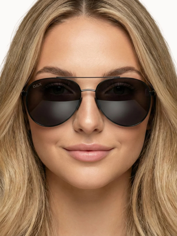 Close-up of a person wearing dark sunglasses with a neutral background