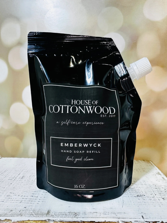 Black hand soap refill pouch with 'House of Cottonwood' branding on a blurred background