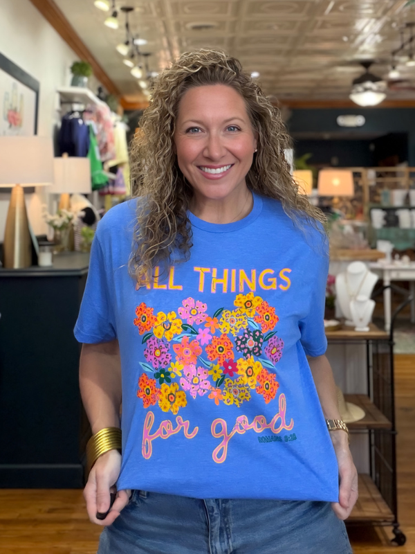 Woman wearing a blue t-shirt with colorful graphics and text in a store setting
