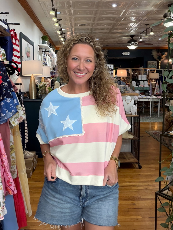 Woman wearing a colorful American flag shirt in a store setting