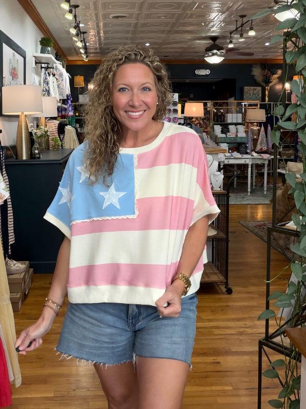 Woman wearing a colorful striped shirt with a star design in a store setting